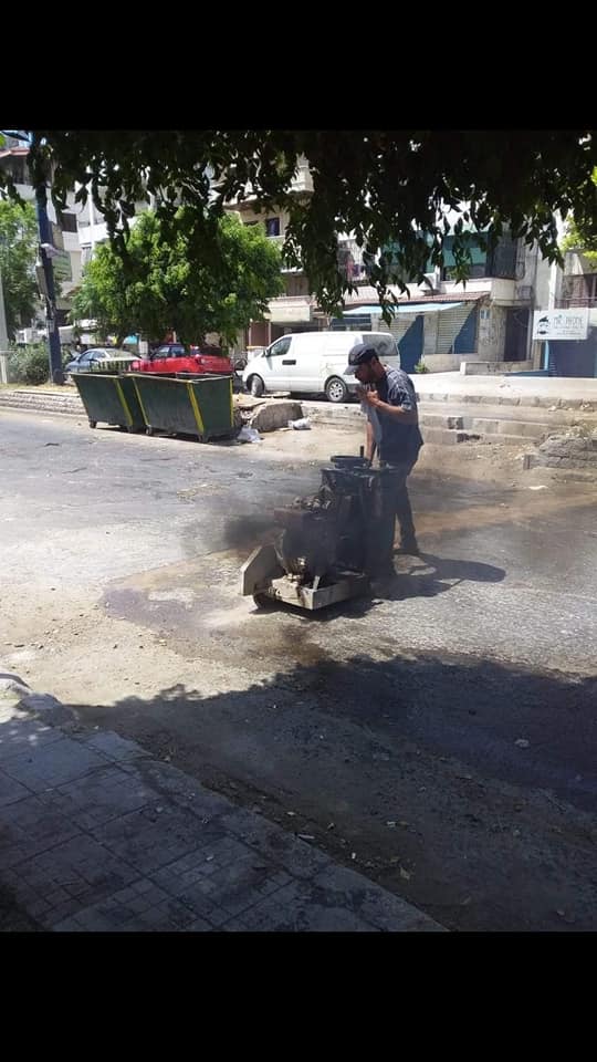 أعمال ترميم للحفر بالمجبول الزفتي في شارع خالد بن الوليد